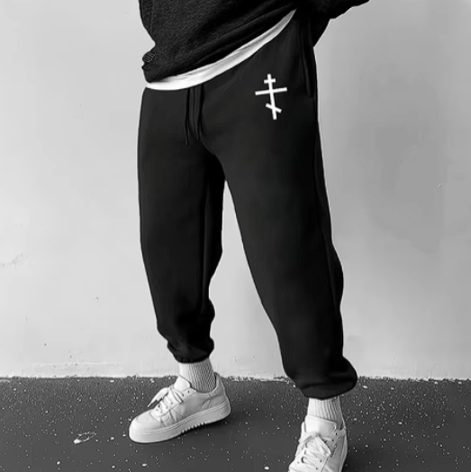 Cristian Sweatpants in black with cross design, featuring relaxed fit and adjustable waistband.