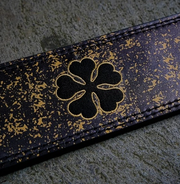 Embroidered shamrock on Black Clover powerlifting belt.